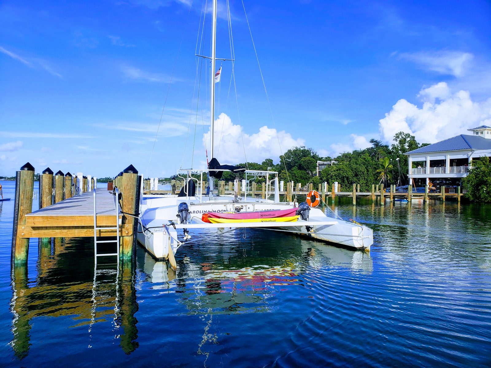 The Carolina Moon catamaran tied up dockside under a bright blue morning sky in Key Largo