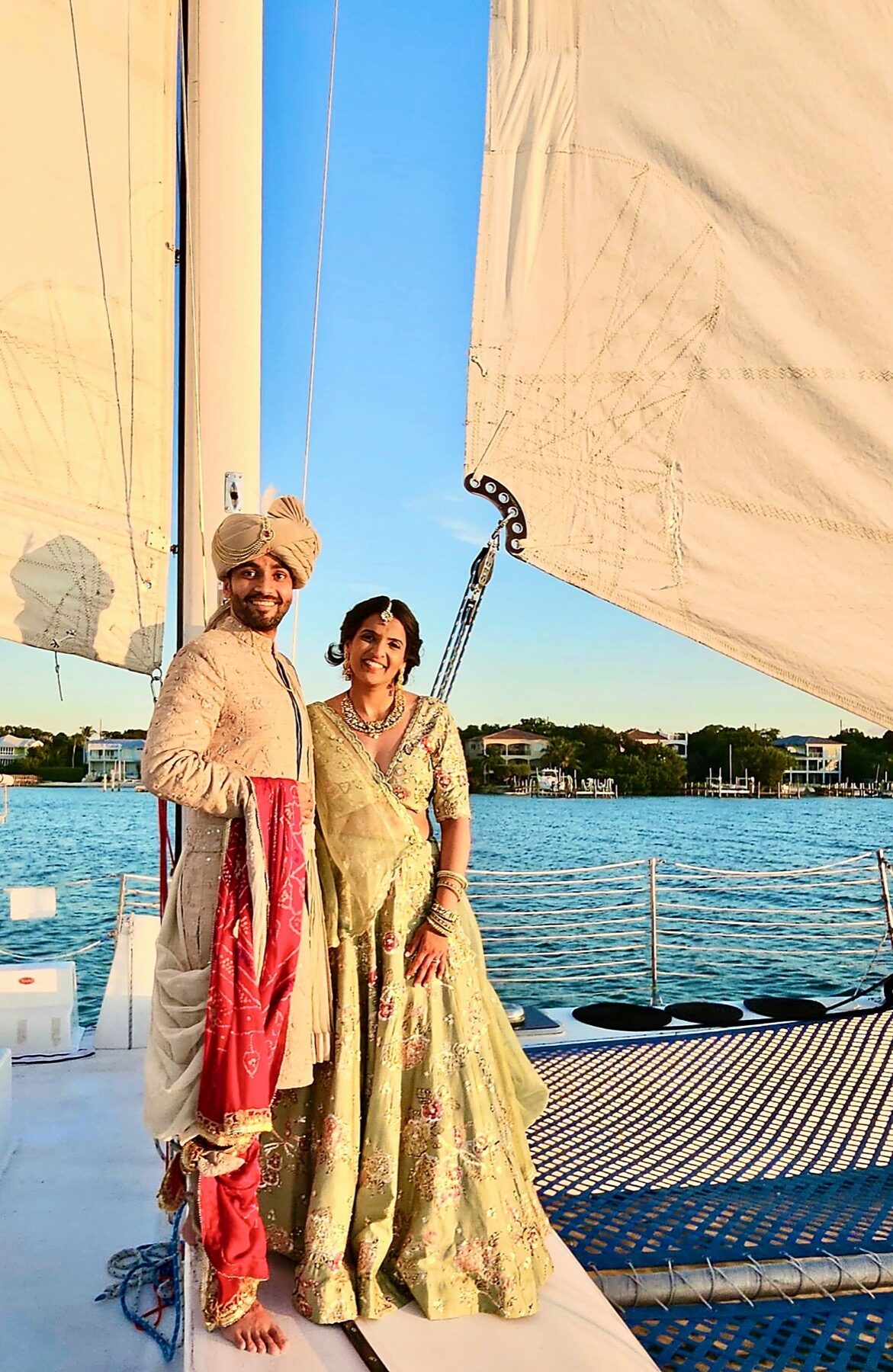 A couple in traditional Indian wedding attire aboard the Carolina Moon catamaran at golden hour on Florida Bay