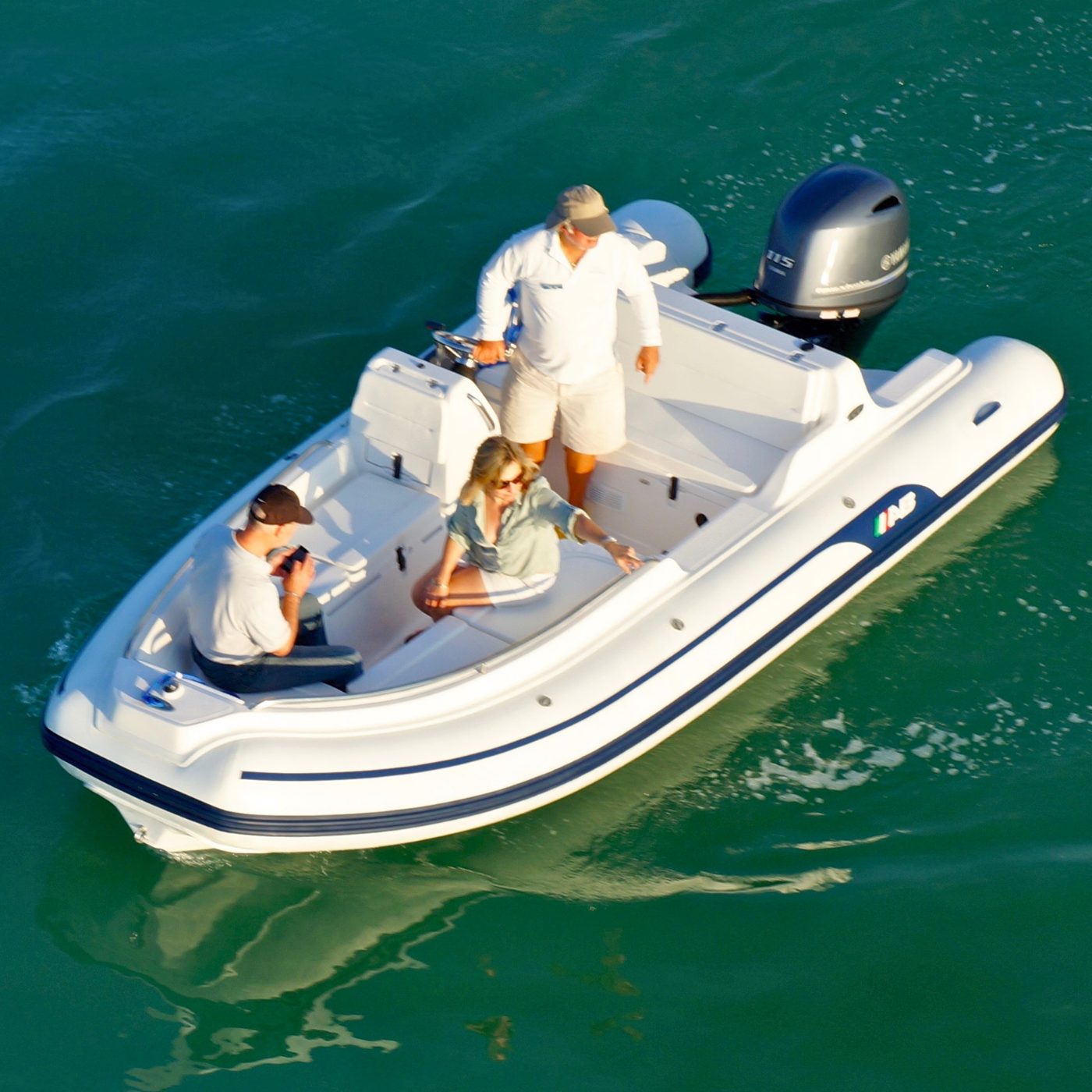 Guests aboard the 17-foot AB inflatable RIB used for Caribbean Watersports eco tours, gliding over clear green water